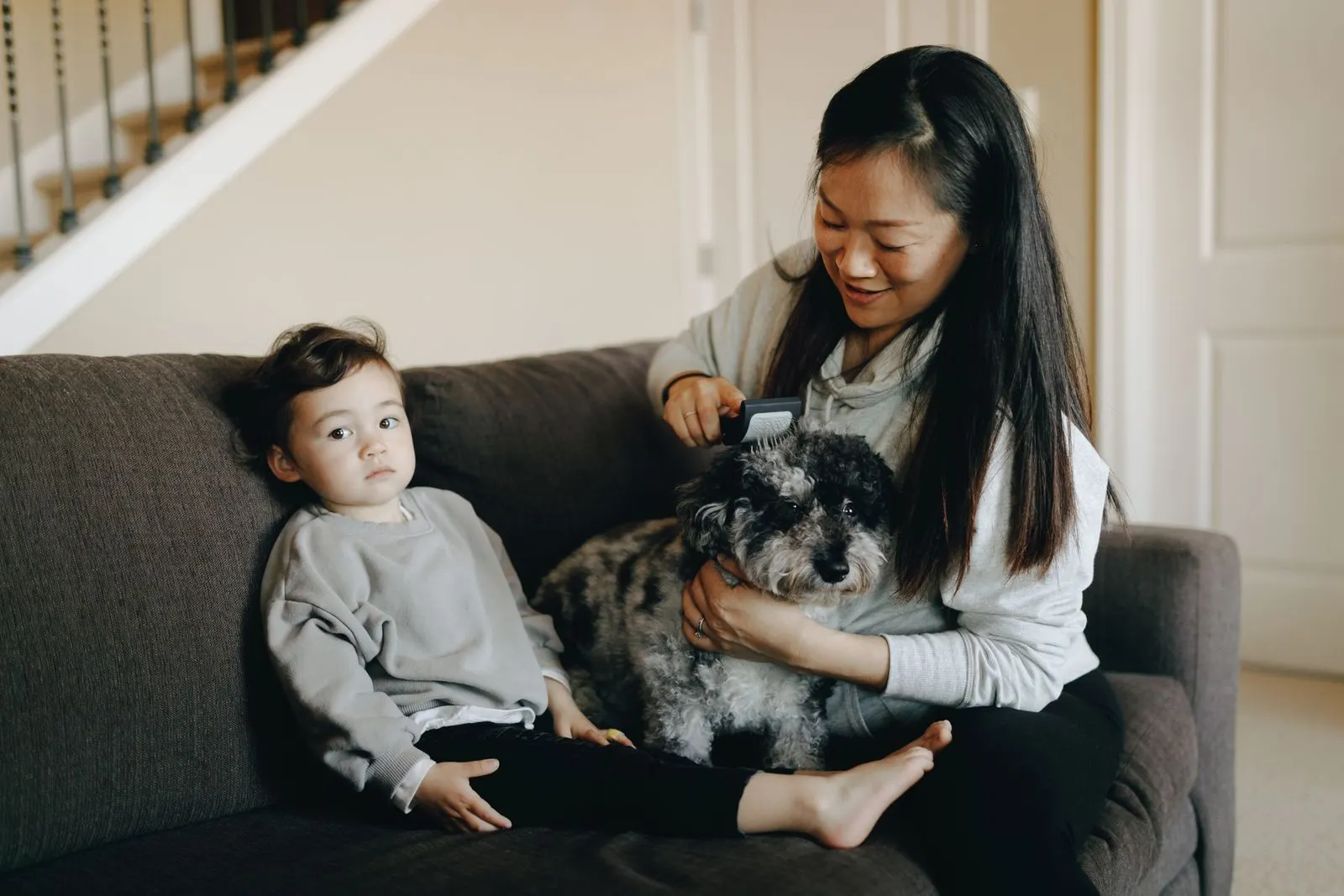 Une mère accompagne son enfant près du chien de la famille